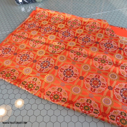 goldene Spiegel auf orange Seidenbrokat Stoffrest