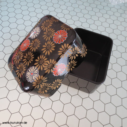 japanische Lackdose mit Chrysanthemen auf schwarzem Grund