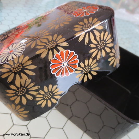 japanische Lackdose mit Chrysanthemen auf schwarzem Grund