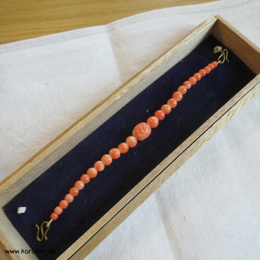 Haori Himo - Koralle, elliptische Mittelperle geschnitzt