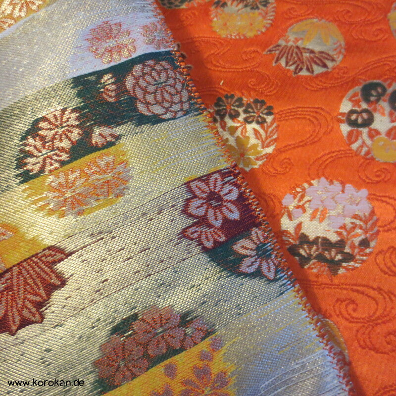 Blumenkringel auf orange breiter Seidenbrokat